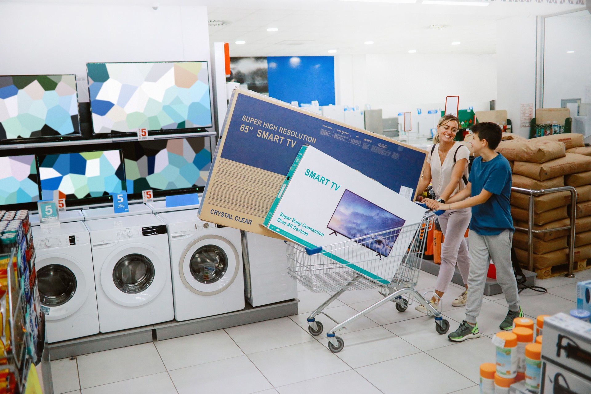 Mom and son buying large TV sets in the shopping mall